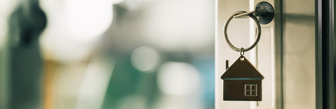 House model and key in house door.